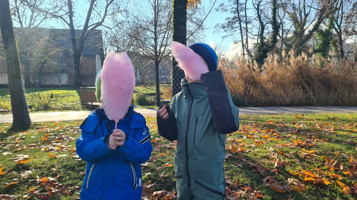 Zwei Kinder essen Zuckerwatte.